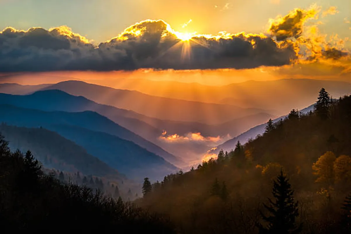 This image captures a mountain range bathed in the warm glow of sunset, with clouds drifting across the sky. The scene evokes a sense of peace and wonder, highlighting the stunning natural setting that guests can experience from the condo's private balcony or during evening strolls.