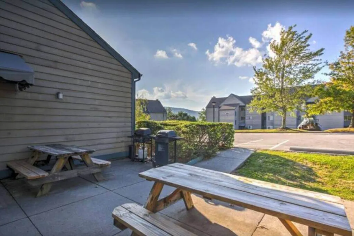 A relaxed outdoor area featuring picnic tables, open greenery, and a stunning mountain view in the background. This inviting setting suggests summer barbecues, community gatherings, or peaceful moments spent unwinding after a day on the trails.