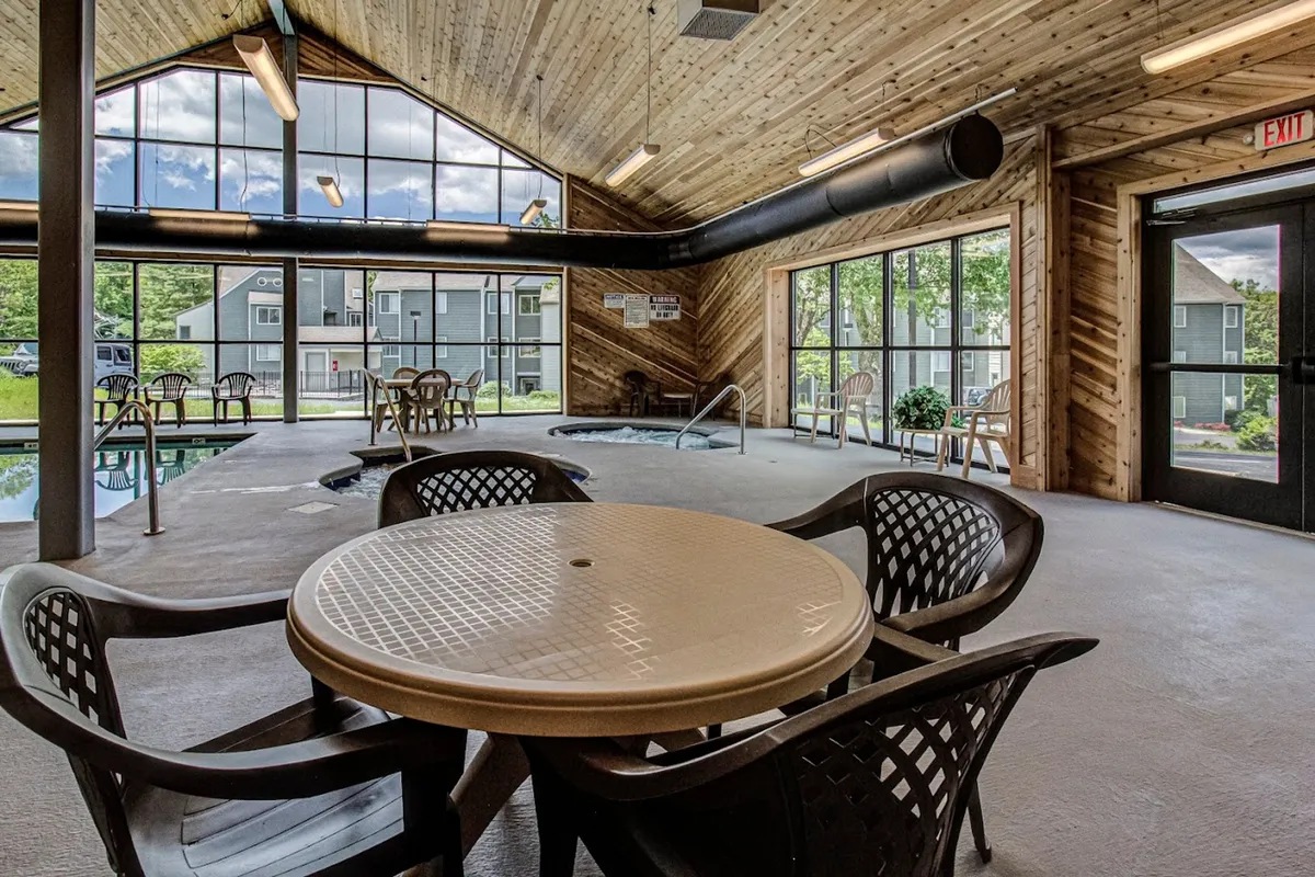 This interior image features a spacious indoor pool area with comfortable seating and large windows, allowing plenty of natural light and a view of the outdoors. The space encourages both relaxation and socializing, ideal for groups after a day spent exploring.